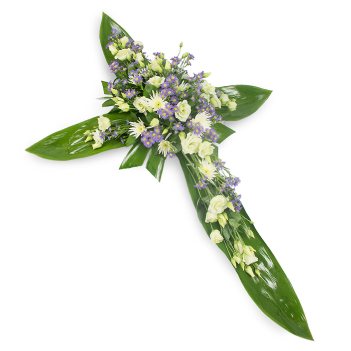This cross-shaped tribute, photographed from a slight overhead angle on a plain white background, balances botanical structure with delicate florals to express quiet devotion. The base is a lattice of large, lustrous green leaves-resembling Ti or similar tropical foliage-positioned to outline the cross's arms and central axis; the leaves' glossy surfaces and visible veins catch a soft studio light and read as protective, embracing wings. Concentrated at the centre and radiating along each arm are clusters of creamy-white lisianthus, their ruffled petals unfolding like small prayerful hands, alongside small, rounded white chrysanthemum-type blooms or spray roses that lend steady punctuation. Scattered among these are sprays of tiny lavender or pale purple star-shaped flowers-likely limonium or small asters-whose cool tones provide a gentle counterpoint and depth. Fine, airy green fillers are woven through the composition, adding nuance and a whisper of movement. The overall feeling is one of calm, reflective dignity: a piece designed for funeral chapels, memorial services, and graveside placements where simplicity and reverence are required. As a local gesture, a florist preparing this for families around Grove Park Nature Reserve or those gathering near Baring Road would aim for understated elegance, ensuring the tribute reads as both a symbol of faith and a loving, composed farewell.