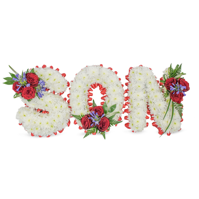 A poignant, meticulously constructed memorial arrangement spells the word SON in three substantial capital letters against a plain white background, the overall effect solemn and reverent. Each letter is formed from a dense layering of pure white spray chrysanthemums or similar small blooms, creating a continuous, cloud-like texture across the face of every character. Along each perimeter, a striking band of bright red ribbon has been pleated into a scalloped border that both defines the letter shapes and provides a bold visual contrast to the white flowers. Three artfully placed clusters soften the geometry: the S carries a bouquet at its upper-left curve, the O holds a cluster at its lower centre, and the N is finished with a spray on its upper-right section. Those groupings combine deep red roses-their velvety petals offering visual warmth-with upright blue-purple spike flowers (reminiscent of Liatris or delphinium) and lush dark green foliage, including fern-like fronds and gentle trailing leaves that give the composition a sense of flow. The arrangement sits in gentle, neutral light that accentuates textures and colour balance, and the subtle scent of roses tempers the restrained perfume of the chrysanthemums. Designed as a personal expression of mourning and lasting affection, this floral lettering conveys purity and peace through white, and undying love through red. I imagine it created by specialist hands familiar with Grove Park's quiet streets and nearby greens-Chinbrook Meadows and Elmstead Woods-meant to rest beside a photograph, on a church chapel stand, or at a graveside as a dignified farewell.