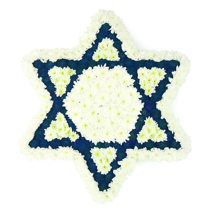 A large Star of David funeral tribute is captured in clear detail, the iconic six-pointed shape made entirely from small, fresh flowers arranged with deliberate care. The arrangement sits against a white background, which allows its two key colours-crisp white and deep blue-to stand out. Around the very edge of the Magen David runs a broad border of white chrysanthemums, their compact, multi-petalled blooms overlapping to create a soft, gently ruffled frame that still keeps the star's geometry sharp. Inside this frame, a solid hexagon of white flowers occupies the centre, forming a bright, tranquil heart to the design. From this central field, six triangular arms radiate outward, each one densely carpeted in dark blue or indigo blossoms, which might be carnations or dyed chrysanthemums, their velvety texture adding depth and a quietly serious tone. At the inner base of every blue triangle, a neat white triangle has been formed, so pockets of white seem to reach back into the darker sections, echoing the interplay of blue and white often seen in Jewish services and gatherings across Grove Park and neighbouring areas like Kew and Chiswick. The flowers are placed so close together that the arrangement appears smooth and cushioned, with no stems showing, just a continuous surface of petals. This Star of David tribute clearly speaks to remembrance and respect, the sort of thoughtful floral piece families in Grove Park might request when they wish to honour a loved one's Jewish heritage with something both symbolic and visually serene for a funeral, memorial, or shiva visit.