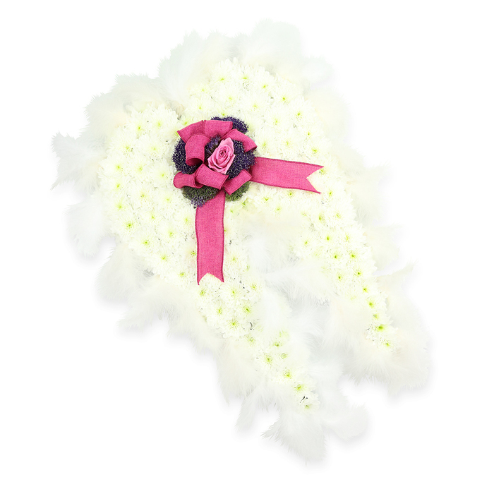 A refined angel wing floral tribute is displayed here, its peaceful beauty heightened by the uncluttered white background. The core of the design is a pair of stylised wings, filled entirely with small, closely packed white chrysanthemums. These blooms create a smooth, velvety surface that feels both pure and comforting, like a soft blanket of petals. Slight touches of pale green at the centres keep the design from appearing flat, adding life and nuance to the white canvas. Running all around the perimeter of each wing is a trim of feathery white plumes, arranged with care so that they follow the natural sweep of wings in flight. The feathers soften the outline, creating a halo effect that hints at spiritual protection and gentle ascent. At the point where the two wings join, colour arrives in a single, striking statement: a wide ribbon of fuchsia-pink satin, tied into a luxuriant bow with full loops and trailing ends that spill elegantly across the wings. Nestled in the centre of this bow is a single pink rosebud, its petals tightly gathered and luminous against the satin, suggesting tender remembrance and a heart still full of love. Just beneath, a cluster of deep violet thistle-like blooms or textured foliage introduces a darker, grounding tone that adds visual depth and a subtle touch of strength. The calm, contemplative nature of this piece makes it especially fitting for services in and around Grove Park, whether in a local chapel off Grove Park Road or at a quiet memorial overlooking the river. It is the sort of thoughtfully designed tribute a neighbourhood florist might create to honour a loved one with dignity and an angelic sense of peace.