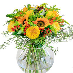 This lavish floral bouquet captures the essence of Grove Park's welcoming charm, placed artfully in a round glass vase much like those displayed at local Thames-side gatherings. Sunflowers preside with their bronzed centers and golden petals, facing outward with open-hearted energy that calls to mind the abundant summer blooms in local gardens. Interlaced with them, buttery yellow garden roses unfurl plushly, their spirals adding a touch of refinement redolent of classic London romance. Encircling the blooms, red hypericum berries dapple the arrangement with bright, spirited notes-playful as laughter during a picnic near Gunnersbury Park. Feathery fern fronds and light green filler sprigs tumble gently outward, creating an airy hedge reminiscent of the lush verges along Grove Park's residential lanes. Subtle silvery eucalyptus weaves among the flowers, cooling the palette and providing delicate fragrance. Down in the clear vase, stems are visible, water magnifying their green vitality and confirming the arrangement's freshness-a hallmark of Grove Park Florist's commitment to local quality and care. The bouquet exudes a sense of festive togetherness, perfect for birthdays, anniversaries, or gracing any room in Grove Park with a sunlit burst of colour and serenity.