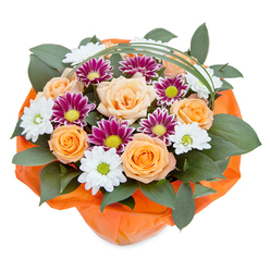 Infused with the welcoming spirit of Grove Park, this vibrant bouquet catches the light from above, set against a white backdrop that enhances its exuberant colours and forms. At the heart of the arrangement are plush, fully opened roses in delicate shades of apricot and radiant orange, their velvety petals evoking the warmth of friendly gatherings along Thames Path. White chrysanthemums, with crisp petals and spring-green centers, add a breath of freshness, echoing the daisy patches found in local parks, while striking magenta chrysanthemums with frilled petals and electric green hearts bring a lively contrast and charm. Glossy, dark green leaves provide a robust, supportive base reminiscent of Grove Park's leafy avenues and riverside spaces, contributing a sense of fullness and natural abundance. Slender arcs of bear grass sweep gracefully above the bouquet, lending an elegant rhythm to the arrangement. The flowers are artfully embraced in a wrap of bright, crinkled orange paper-its cheerful tone capturing celebratory moments from Grove Park's vibrant community life. The collective artistry and attention to detail make this bouquet perfect for local flower delivery, marking special occasions or simply adding colour and joy to a friend's home.