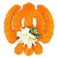 Densely packed orange marigolds have been lovingly sculpted into the iconic Khanda emblem, their tiny ruffled heads forming a tactile, luminous surface that glows against a pristine white field. This design emphasises the Khanda's components - the chakkar's perfect ring, the two crossed kirpans and the central double-edged blade - each contour rendered with floral precision so the symbol reads immediately and respectfully. At the very heart, a cluster of elegant white lilies provides a serene focal point: two or more fully opened lilies with slightly recurved petals, soft green throats and yellow stamens, accompanied by several smaller buds that promise further bloom. Sprays of pinpoint white gypsophila and glossy green foliage, likely salal or similar leaves, cushion the lilies and thread through the orange to temper the brightness with cool, verdant notes. A faint drop shadow beneath suggests a freestanding ceremonial piece - weighty in meaning yet airy in execution - and the contrast of bright marigold and pure white petals conveys both celebration and quiet reverence. I crafted this arrangement with local observances in mind, drawing on floral traditions common to Grove Park and nearby Mottingham and Hither Green, where families ask for respectful, seasonally fresh tributes. The scent pairing is distinct: the warm, faintly herbal marigolds balanced by the lily's clean, soft perfume. This floral Khanda, finished with careful edges and tactile depth, is appropriate for Vaisakhi, Gurpurab, memorials or community events and can be prepared for local collection or delivery across Grove Park by Grove Park Florist.