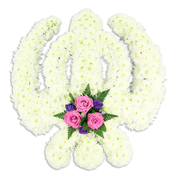 A solemn yet soothing Sikh Khanda floral tribute is portrayed against a pure white backdrop, its iconic shape rendered with expert precision. The central double-edged sword, the encircling Chakra, and the sweeping crossed Kirpans are all formed from a dense blanket of white chrysanthemums, each small head carefully placed so that their soft, intricate petals blend into one continuous surface. From a distance, the Khanda seems carved out of white velvet; closer, you can almost sense the cool, slightly springy touch of each bloom. The even, pale lighting gives the petals a gentle luminescence, emphasising the purity and spiritual focus of the symbol.   

Nestled at the very base of the arrangement, between the meeting points of the Kirpans, a contrasting spray of colour adds emotional depth. Three pink roses, at the perfect stage of opening, form the centre of this small bouquet, their spiralled petals suggesting affection, gratitude, and respectful farewell. Around them, deeper purple flowers cluster in rich tones, offering a contemplative counterpoint to the soft white. Fine green fern fronds and other foliage extend delicately from the base, creating a frame of fresh greenery that brings a sense of life and continuity.   

This carefully composed tribute could easily be envisioned at a Sikh funeral or memorial gathering in Grove Park, nearby Chiswick, or travelling quietly through local streets to a Gurdwara. It captures both the solemnity of loss and the comfort of shared faith, a floral emblem that speaks in silence for families marking a final farewell, handcrafted with sensitivity and understanding of Sikh customs.