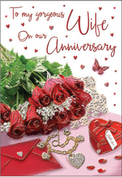 An elegant anniversary composition seems to rest on a sunlit table in Grove Park, where romance is captured through roses, keepsakes, and a handwritten card. At the centre lies a small gathering of red roses, each bloom luxuriously full, their petals curling outward in rich crimson layers that suggest both passion and comfort. The roses are framed by fresh green foliage, whose softer, cooler tones offer gentle contrast and make the red appear all the more vivid, like a bouquet kept in a bright kitchen near Grove Park Common. Nestled alongside the flowers is an envelope with a neatly folded flap, its creamy paper lending a calm, classic backdrop to the more decorative elements. A heart-shaped box rests nearby, its smooth, glossy finish catching the light in a way that hints at a cherished gift held within. A piece of jewellery lies close, its metallic shine and delicate shape reinforcing the theme of treasured moments and promises kept. Tiny red hearts are scattered across the surface as though sprinkled by hand, leading the eye toward the card's romantic script, which appears to float among the decorations. A single butterfly motif, light and graceful, introduces a touch of whimsy and movement, suggesting the fluttering excitement of an anniversary remembered well. Soft, natural light illuminates the whole arrangement, casting light shadows that give depth to the roses and definition to every object. The result is a still life rich in feeling, like an anniversary gift assembled with care by Grove Park Florist, designed to honour a love that continues to grow with each passing year.