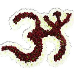 There is an intimate devotion woven into every curve of this floral Om, carefully assembled from dense clusters of small chrysanthemum-like blooms to form the sacred Sanskrit character against a spotless white background. The heart of the symbol - the sweeping '3' curve, the downward flowing stroke and the small crescent and dot above - is filled with deep maroon to burgundy flowers, each tiny head revealing a lime-green centre that punctuates the darkness with a fresh, organic highlight. A generous border of crisp white spray chrysanthemums travels the outer edge and the interior hollows, their chalky petals creating a luminous frame that accentuates the symbol's iconic silhouette. The arrangement is lush and sculptural; the petals sit tightly together to create a soft, velvety surface that looks almost tactile in the studio light, and a subtle drop shadow confirms its three-dimensional presence on the white plane. A gentle, earthy fragrance - like late summer chrysanthemums and green stems - would meet the nose on approach, offering a quiet, consoling note suitable for memorial altars, puja ceremonies, or mindful gatherings. As Grove Park Florist often prepares for families around Baring Road, this piece reads as both a devotional offering and a crafted artwork: respectful, precise, and thoughtfully balanced for ritual or remembrance in local community spaces such as Chinbrook Meadows and nearby Downham halls.