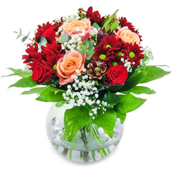 Picture yourself holding this sumptuous bouquet, its textures soft and luxuriant, as if fresh from the flower markets near Grove Park. Plush red roses and velvety red chrysanthemums nestle around glowing apricot and salmon roses, their sunlit warmth softened by a gentle mist of gypsophila resembling the delicate blossoms you might find along Fauconberg Road in early spring. Anchored by verdant, glossy foliage, the composition feels alive-each leafy detail reminiscent of the vibrant growth in Chiswick Park or the greenery of nearby gardens. Clear water in the rounded vase magnifies the promise of life and freshness, symbolic of the thriving spirit of this local community. The bouquet radiates harmony: every bloom, every sprig of gypsophila, is carefully chosen and masterfully arranged by Grove Park Florist's skilled hands. Movement within the bouquet draws the eye outwards, yet the flowers remain lovingly gathered at the heart, echoing the connectedness of neighbours and friends. Fragrances of sweet, classic rose and cool, verdant greens blend to create an uplifting atmosphere-perfect for birthdays, anniversaries, or marking cherished milestones at home in Grove Park. More than a simple arrangement, this bouquet is an embodiment of artistry, local freshness, and heartfelt sentiment-ready to bring beauty to any special moment.
