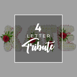 A richly detailed photograph focuses on a bespoke floral letter tribute spelling out a four-letter word, the kind often used to display a name or tender message at a funeral or memorial gathering in Grove Park. The letters stand side by side, each one entirely covered in compact white chrysanthemums, their tiny petals overlapping like delicate lacework. This dense covering gives the tribute a plush, cushion-like feel, suggesting comfort and purity. Around the outer edges, a narrow strip of pale pink ribbon traces the contours of each letter, introducing a soft touch of colour that gently frames the design without overwhelming it. Scattered thoughtfully among the chrysanthemums, deep crimson-red roses emerge, their blooms unfurling in graceful spirals. These roses are paired with sprigs of lush, dark green foliage, the leaves providing a natural backdrop that enhances the richness of the red petals. The combination of white, pink, red, and green creates a harmonious, heartfelt palette suited to moments of remembrance. The background is a calm, light grey, unobtrusive and smooth, so that all attention remains on the floral artistry. There is no clutter or additional decoration, only the flowers themselves and the tender message they convey. The image feels intimate, as though you are standing close enough to reach out and touch the soft chrysanthemums or inhale the faint fragrance of the roses, capturing the quiet dignity and respect that such personalised letter tributes bring to services held around Grove Park and its surrounding communities.