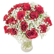A timeless, domed bouquet of roughly 18-20 deep crimson roses, each bloom opening in velvety spirals, is gently nestled within a cloud of frothy white baby's breath (Gypsophila paniculata) and set in a clear glass vase. The arrangement reads as a compact, rounded composition: the rich, saturated crimson of the roses creates a warm, passionate core while the countless tiny, snow-like blossoms of the gypsophila soften and lift the silhouette, producing an airy halo that tempers the intensity of the reds. Light falls evenly across the petals, picking out subtle highlights on the velvet surfaces and revealing the translucent green of the long stems through the vase; waterline and stems are plainly visible, lending a natural, honest integrity to the design. A faint, classic scent of rose-sweet, green, and slightly honeyed-seems to hang in the imagined space around the bouquet, balanced by the almost neutral, powdery hint of the baby's breath. The tactile contrast is immediate: smooth, dense petals against the whisper-light tufts of gypsophila, which together invite both touch and close, quiet attention. This is a bouquet that reads as romantic and celebratory at once-equally suitable for an anniversary dinner in a small Grove Park flat, a thoughtful Valentine's Day surprise delivered near Grove Park station, or a heartfelt gift left on the kitchen table after a walk through Chinbrook Meadows. The composition feels handcrafted but effortless, an expression of steady affection made to be seen, smelled, and treasured.