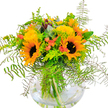 This sunshine-filled bouquet captures the essence of late summer in Grove Park with exquisite artistry. Towering sunflowers dominate the arrangement, their glowing yellow petals unfurling in bold contrast to soft, chocolaty centers, inviting the warmth and cheer of a golden day by the Thames. Two principal blooms lead the scene, supported by smaller clusters of lively yellow fillers-mimosa or solidago-that scatter bursts of light throughout. Emerging from the bouquet's heart are subtle flashes of coral-orange, likely tulips, that gently brighten the palette and hint at the fresh energy of Chiswick festivals. Deep green fern fronds drape elegantly, weaving organic shapes around the flowers, while velvety, blue-green eucalyptus brings a hint of contemporary West London flair and fragrance. Every element is anchored within a round, clear vase, the submerged stems arranged with precision, their vivid lines magnified through still water. The mood is one of celebration and hope-a perfect centerpiece for local parties, thoughtful deliveries to a loved one, or simply bringing the joy of open skies and parkland indoors. Artfully arranged and locally inspired, this bouquet is a testament to the community's enduring appreciation for beauty, seasonality, and the simple pleasure of fresh blooms delivered across Grove Park.