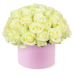 A generous dome of roses in creamy white and pale ivory tones, kissed with subtle hints of pastel yellow in their centres, rises gracefully from a round pastel pink hat box, creating a sophisticated and romantic focal point against a pure white background. The roses are arranged so closely that the surface of the bouquet appears almost seamless, a soft, pillowy landscape of layered petals that curl gently outward in classic rose spirals. Each bloom looks freshly opened, with velvety petals that seem cool and silky to the touch, conveying a sense of abundance and careful craftsmanship. Tiny flashes of delicate green foliage are visible only near the very base of the dome, offering the lightest suggestion of leaves beneath the lavish sea of petals, and ensuring the predominant impression remains one of creamy, luminous softness. The hat box itself is a gentle blush pink cylinder with a matte, refined finish, reminiscent of elegant gift boxes found in boutique shops not far from Grove Park station or along nearby local high streets. Its simple, modern lines provide a contemporary frame for the opulence of the roses, balancing romance with stylish restraint. Bathed in even, flattering light, the entire arrangement exudes calm, celebratory elegance, making it easy to imagine this piece placed on a console table in a Grove Park home, gracing a riverside restaurant as an anniversary centrepiece, or arriving as a thoughtful, same-day delivery from a local florist to mark a significant milestone in a quietly luxurious way.