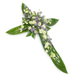 A solemn, carefully constructed floral cross photographed on a clean white background from a slight overhead angle so every line of the design is clear. The structural shape is formed from broad, glossy tropical leaves-think Ti or similar-laid edge to edge to create the horizontal and vertical arms of the Christian cross; their deep green surfaces show subtle veins and a soft, waxy sheen where the studio light catches them. At the intersection and running along each arm is a dense, tender spray of blooms in a quiet palette of creamy ivory, soft white, and pale lavender. Ruffled lisianthus in creamy white provide the principal, layered texture while clusters of small, rounded white chrysanthemum-type blooms or miniature spray roses punctuate the composition with bright points. Interspersed through the spray are tiny star-shaped lavender accents-likely limonium or small asters-that lift the arrangement with a cool, gentle colour contrast, and fine green filler foliage weaves through to soften edges and add depth. The overall scent would be faintly green and floral rather than sweetly overpowering, lending an atmosphere of calm reflection. This is a classic sympathy piece, intended for funeral chapels, church services, or graveside ceremonies, conveying reverence, hope, and serene remembrance without excess. A local florist might place such a tribute on a white altar or beside a memorial photograph; in Grove Park and surrounding Lewisham communities it is a dignified choice for families seeking a modest, reverent expression of condolence crafted with respectful care.