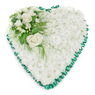 The photograph shows an elegant heart-shaped funeral flower arrangement, thoughtfully crafted and displayed against a bright, uncluttered white background so that every detail is clearly visible. The body of the heart is made entirely from white chrysanthemums, tightly clustered so their flower heads form a thick, cushioned layer of petals. This expanse of white feels calm and comforting, like a soft blanket laid gently in memory of a loved one. Each bloom contributes to a sense of purity and peace, making the heart suitable for a sensitive farewell or memorial service. Running around the edge of the heart is a rich emerald green satin ribbon, pleated into fine, delicate folds that ripple along the border. The ribbon has a gentle shine, offering a refined contrast to the flowers' velvety texture and giving the design a formal, respectful finish. At the upper left curve, a refined accent spray adds focus and depth. Two creamy white roses, fully open, sit at the centre, their layered petals spiralling outward with quiet grace. They are accompanied by smaller white flowers-reminiscent of freesias or other slender-petalled blooms-and a few buds, adding variety and hinting at life continuing even in sorrow. Lush green foliage surrounds and supports this cluster, combining broader shiny leaves with airy, fern-like fronds that reach across the chrysanthemum base. The arrangement could easily be imagined resting by a coffin, on a stand in a chapel near Grove Park station, or at a graveside in a nearby cemetery. It conveys a message of sympathy, love, and remembrance through flowers arranged with care and local expertise.