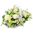 This image shows a tranquil and sophisticated sympathy flower basket, designed with understated grace that would suit the peaceful streets and riverside scenery of Grove Park. The basket itself is a light beige or soft white woven wicker, with a smooth handle that arches over the arrangement and adds a gentle, traditional touch. Inside the basket, a full, rounded bouquet has been expertly shaped, the flowers rising just above the rim in a soft dome. At the centre, large creamy white roses bloom in perfect circles, their velvety petals fully unfurled and layered, creating a sense of purity, comfort, and quiet remembrance. Interspersed between these roses are distinctive clematis flowers, their star-shaped petals in pale lavender and subtle periwinkle tones, each bloom highlighted by a bright yellow-green centre that adds a delicate spark of colour. Threading through the arrangement are smaller, freesia-like clusters in white and soft yellow, some tight and promising, others open and airy, suggesting both memory and renewal. A generous amount of dark green foliage surrounds and supports the blossoms, with glossy broad leaves and finer stems adding contrast and giving the design a fresh, just-arranged appearance, as if it has been prepared that morning by Grove Park Florist for delivery to a local service or family home. The pure white background ensures the gentle pastels and rich greens stand out clearly, heightening the sense of calm and sincerity. Overall, the basket feels like a compassionate, thoughtful tribute, appropriate for funerals, memorials, or sending condolences throughout Grove Park, Chiswick, and the surrounding neighbourhoods.