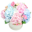 This exquisite arrangement, nestled inside a pristine white round hatbox, radiates soft luxury in pastel pinks and powdery blues. The crown is dominated by lush pink peonies, their many delicate petals catching the light, while cloud-like clusters of pale blue hydrangeas provide a cool, airy counterpoint. Interleaved among the main blooms are pale pink spray roses with their furled buds adding subtle texture, and two trumpet-shaped calla lilies in a deeper rose hue that rise gracefully-one near the top-left and the other peeking from the bottom-right. A touch of greenery-hydrangea leaves with a whisper of dusty miller-frames the blossoms and deepens the colour contrast. The composition forms a full, rounded dome, crafted with the precision and care you'd expect from a dedicated Grove Park Florist, making it a sophisticated gift for birthdays, anniversaries, baby showers, or gender reveals. It's the kind of bouquet that whispers romance and refined elegance, designed to brighten homes, offices, or event spaces across Grove Park. Perfect for same-day delivery within the Grove Park area and nearby streets, this arrangement pairs timeless beauty with subtle modernity, a reliable expression of joy for celebrations large and small alike, hand-assembled to travel safely and arrive pristine at its destination.