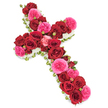 A classic Christian cross crafted entirely from fresh flowers is shown against a pure white background, its elegant shape and rich colouring making it a poignant funeral tribute. The cross is densely packed with deep red roses, their velvety petals fully opened and layered, forming a continuous, cushion-like surface along both the vertical stem and horizontal bar. Interspersed throughout are vivid fuchsia pink roses and garden-style blooms, whose slightly ruffled, softer petals add a gentle contrast and a warm glow to the more solemn crimson tones. Between the larger blossoms, small rosebuds in harmonising shades of red and pink appear, adding texture, depth, and the quiet suggestion of remembrance that continues to grow. Encircling the entire outline of the cross is a narrow border of tiny white flowers-reminiscent of spray chrysanthemums, miniature carnations, or fine gypsophila-that creates a crisp, delicate trim, enhancing the sacred profile while lending an air of peace and serenity. Just beneath the lush tapestry of petals, subtle touches of deep green foliage and possibly slender ribbon can be glimpsed, helping to support the structure and define the silhouette without drawing attention away from the roses. The overall impression is one of calm reverence, like stepping into a small Grove Park church or gathering with family near the tree-lined streets and quiet gardens of the area. Suitable for funeral services, wakes, and graveside farewells around Grove Park, this floral cross offers a dignified and heartfelt expression of sympathy, embodying both faith and enduring love in a single, beautifully arranged tribute.