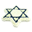 A generously sized Star of David funeral tribute is shown in close detail, resting against a plain white background that highlights its shape and colours. Constructed entirely from compact chrysanthemum heads, the arrangement has a smooth, padded surface where each bloom nestles tightly alongside the next. The florist has used pure white flowers to outline the entire six-pointed star and to fill the central hexagon, creating a serene, luminous frame and centre. Inside this white structure, the two overlapping triangles that form the recognized Jewish symbol are filled with rich navy-blue blossoms, which stand out with clear, defined edges and give the star its striking geometry. The deep blue tones feel steady and contemplative, while the white suggests peace, remembrance, and the hope of comfort for the family. Soft, even lighting brings out subtle variations in the petal textures, casting tiny shadows that lend a gentle three-dimensional effect. This is the kind of floral tribute that might be displayed at a synagogue or funeral chapel serving families from Grove Park and nearby riverside streets, offering a focus for prayer and reflection during a time of loss. Its simplicity-just two colours, no foliage, no ribbons-emphasizes the importance of the symbol itself. The arrangement feels both personal and communal, reflecting the shared heritage of the Jewish people and the intimate grief of one family. Designed by skilled local florists in Grove Park, this Star of David arrangement provides a respectful, meaningful farewell, combining traditional symbolism with the quiet language of fresh flowers.