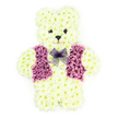 This beautifully constructed floral teddy bear, photographed against a pure white background, serves as a tender and symbolic funeral or memorial tribute. The teddy's entire body is sculpted from countless creamy white chrysanthemums, their tightly packed petals building a dense, velvety surface that suggests the touch of soft toy fur. The florist's craftsmanship is clear in the way the head, rounded ears, compact arms, and short legs are shaped, with discreet shadows in the folds of petals adding dimension and realism. Two small, dark floral centres become bright eyes, another forms the neat nose, and a gently curved line of darker blooms indicates a kind, almost comforting smile that seems to watch over the space it occupies. A waistcoat of vivid purple and lilac flowers is carefully arranged across the chest, with clearly defined lapels and panels that contrast beautifully with the creamy fur, giving the bear a dressed, almost ceremonial appearance. At the neckline, a delicate lavender mesh bow tie rests lightly, its translucent loops creating a soft, graceful accent. One can imagine this arrangement being prepared by a florist in Grove Park, perhaps destined for a quiet service near the river or a family farewell in a local chapel. The overall effect is one of innocence, warmth, and gentle remembrance, making this floral teddy bear particularly suited to honouring a child or a loved one whose memory is linked with kindness and playfulness, while offering families in Grove Park a tender, visually soothing focal point during moments of deep reflection.